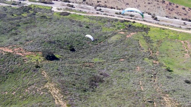 Para-glider over the top of the mountain during summer sunny day. Para-glider on the para-plane, strops -soaring flight moment flying over Black Mountain in San Diego, California. USA