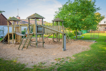 Fototapeta na wymiar a wooden climbing frame stands on the premises of a kindergarten