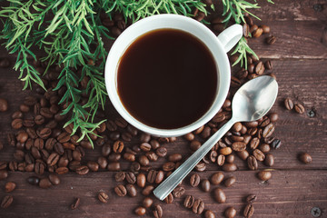 Cup of coffee, coffee beans on a dark wooden table