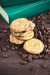 Coffee beans, cookies and book on a dark wooden table