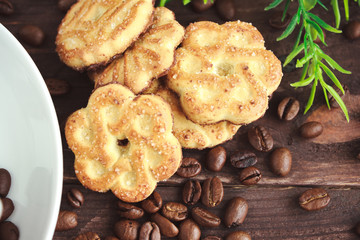Cup of coffee, coffee beans and cookies on a dark wooden table