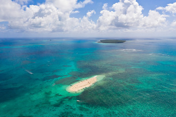 Fototapeta na wymiar Naked Island, Siargao. The island of white sand on the atoll. Tourists relax on the white island. Seascape with sandy island.