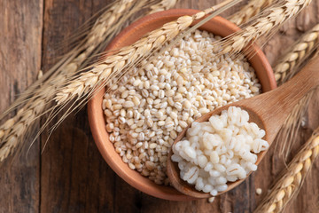 Cooked peeled barley grains in wooden bowl