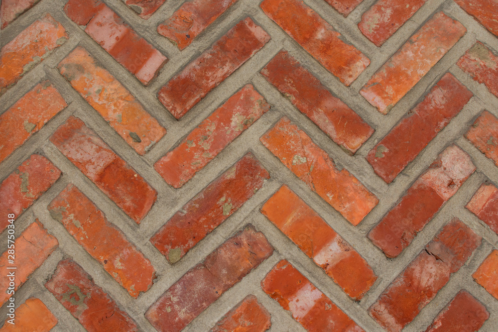 Wall mural background, orange brick wall with a herringbone pattern image taken horizontally