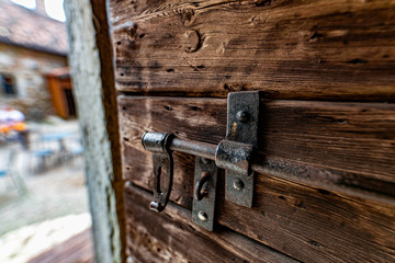 Catenaccio in ferro di un vecchio portone in legno con venature