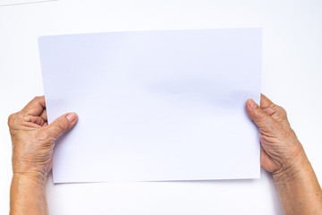 Senior woman's hand holding white paper on white background