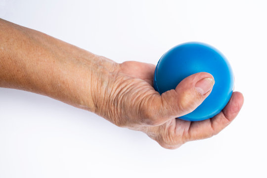 Senior Woman's Hand Holding Blue Stress Ball Isolated On White Background