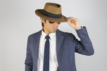 Young Asian Portrait Businessman Wear Sunglasses and Touch Hat Brim in Front View