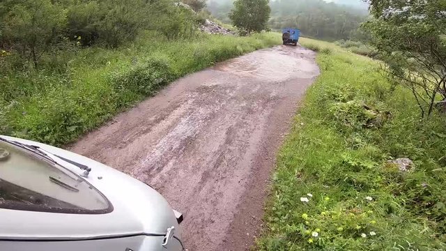 By car out of road. Car passes the road with stones, puddles and mud. Off the road travel on mountain.