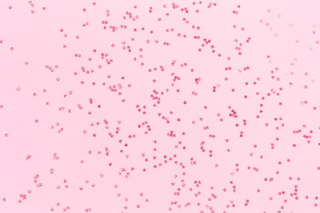 Red holographic star glitter  festive confetti on pink background