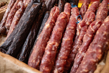Variety of dried sausages in a basket at farmer's market in london