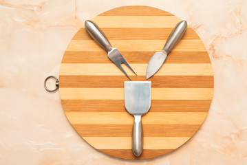 round wooden tray with flatware setting for cheese
