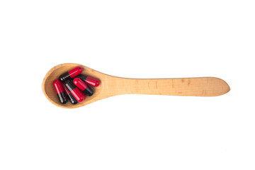  pills in wooden spoon