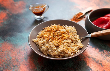 Traditional for Turkish, Greek and Iranian cuisine, a dish called Keskek. Served with pickled red peppers, butter and paprika powder. Close-up, copper background, copyspace