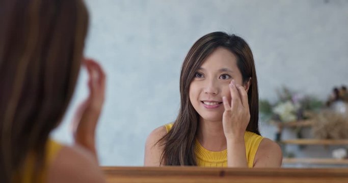 Woman use finger touch on her face in beauty make up studio