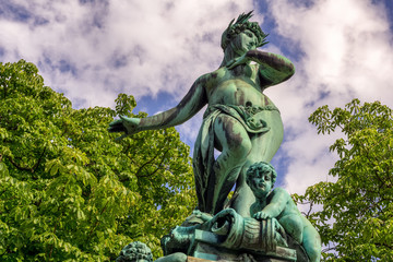 Obraz premium The old statues of a woman and a boy on a public place