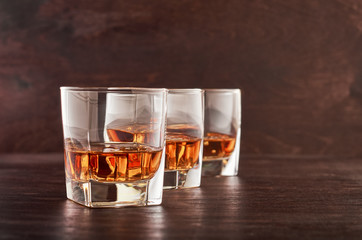 Glass of whiskey on a wooden tableTwo glasses of whisky with ice on a wooden table