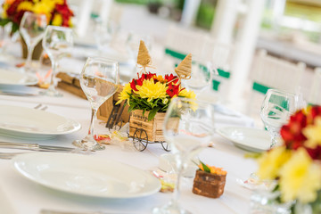 Wedding table set up decoration made of red and yellow fresh flowers. Rustic/ garden wedding decoration