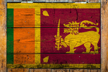 National flag of Sri Lanka on a wooden wall background.The concept of national pride and symbol of the country.Flag painted on a wooden fence with metal nails.