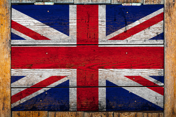 Fototapeta premium National flag of United Kingdom. on a wooden wall background.The concept of national pride and symbol of the country.Flag painted on a wooden fence with metal nails.