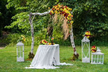 Wedding arch made of red and yellow flowers 