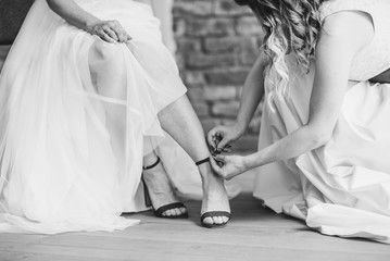 Bride getting ready by a bridesmaid