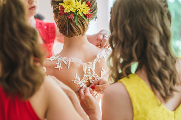 Naklejka premium Bride getting ready by a bridesmaid