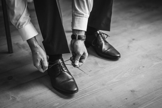 Groom Tying His Shoes on the wedding day. Black and white image