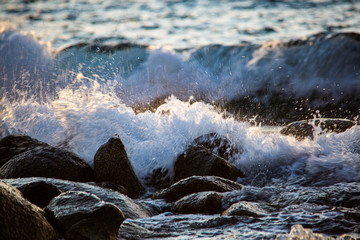 Water splashes against rocks, troubled sea, spray