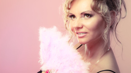 Woman holding carnival feather fan in hand.