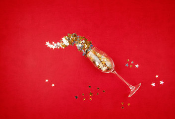 Top view glass of champagne and golden confettie. Party, new year, christmas, birthday celebration