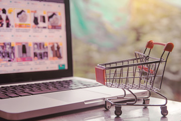 Shopping online concept - shopping cart or trolley on a laptop keyboard. Shopping service on The...