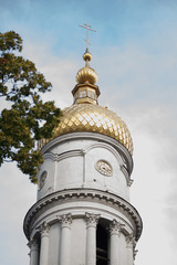 Close up of the dome of the church with golden crosses against the blue sky with clouds, soft focus