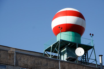 Bottom view of the red-white sphere on the building of the meteorological service against the blue sky