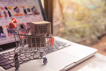 Shopping online concept - Parcel or Paper cartons with a shopping cart logo in a trolley on a...