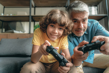 Mature father with son playing in video games