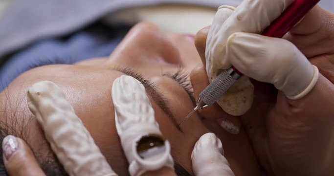 Woman having microblading on eyebrow