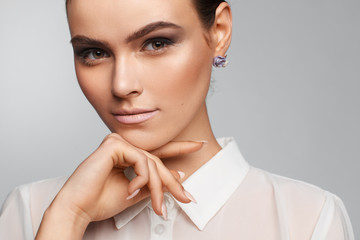 Portrait of a beautiful pacified woman in a white shirt. Studio photo session