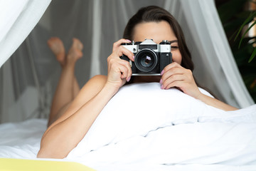 Young woman taking picture with retro camera