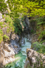 Scenic view of a canyon with a wild stream of turquoise colored water in the Alps