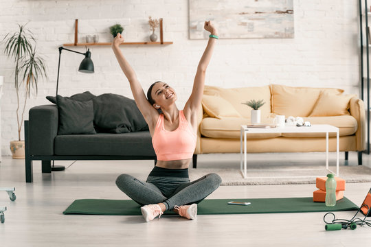 Happy fit female stretching in sitting-room stock photo