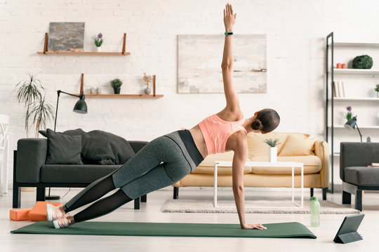 Female practicing side plank at home stock photo