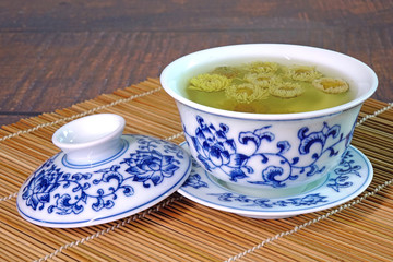 Chrysanthemum tea. Chinese tradition chrysanthemum tea in beautiful blue and white porcelain cup, famous herbal tea from Huangshan , Anhui China. Selective focus, space for texts.