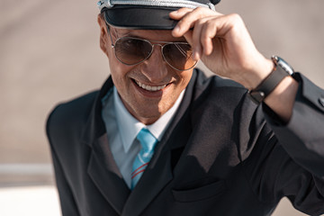Caucasian mature man in sunglasses smiling to camera