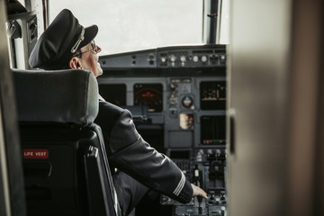 Smiling man in uniform accelerating on throttle during flight