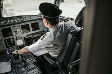Professional pilot in cockpit looking through window of plane © Yakobchuk Olena