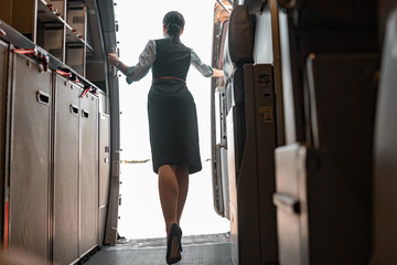 Tall female flight attendant is on duty on board