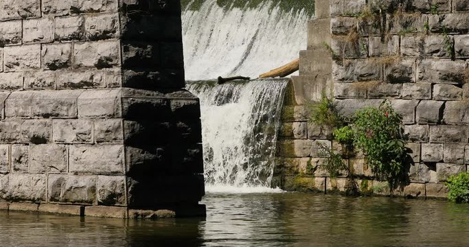 Erie Canal rock bridge over flow waterfall New York. Pioneer engineering wonder. 363 miles long man made waterway built in 1817. Transport of cargo from eastern ports and cities.