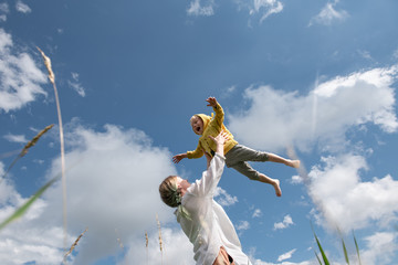 mom throws her little son up in the sky