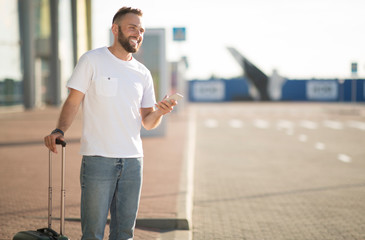 Man using phone app for ordering taxi, arriving at airport